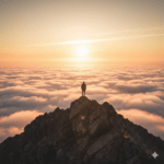 Ein Mensch steht bei Sonnenaufgang auf einem Berggipfel und blickt über die Wolken – Symbol für Motivationszitate und Perspektive.