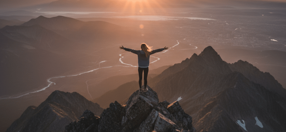 Nachlassende Motivation: Eine Person genießt den Ausblick auf dem Gipfel bei Sonnenaufgang als Symbol für wiedergewonnene Motivation.